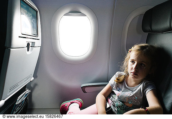 Ein kleines Mädchen sieht sich im Flugzeug einen Film an.