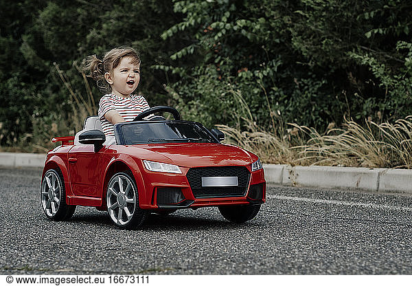 Ein Mädchen fährt ein Spielzeugauto