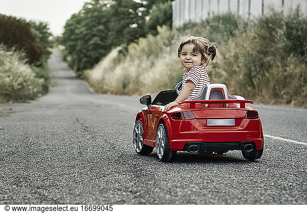 Ein Mädchen fährt ein Spielzeugauto
