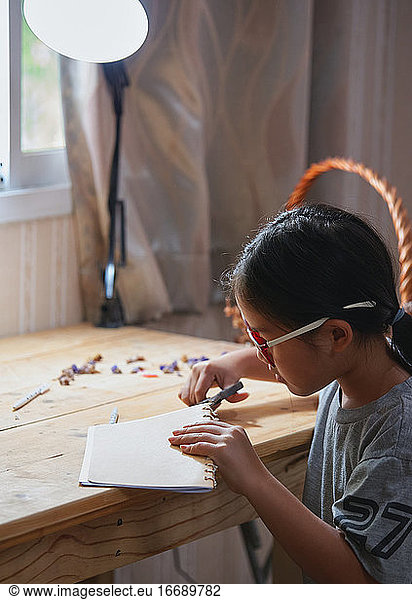 Ein Mädchen schneidet ein Seil auf ihrer Hand Handwerk Arbeit