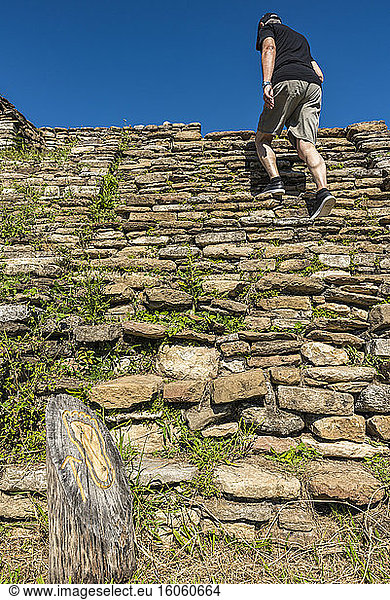 Ein männlicher Tourist erklimmt die steilen Steintreppen von Tonina  der präkolumbianischen archäologischen Stätte und Ruinenstadt der Maya-Zivilisation; Chiapas  Mexiko