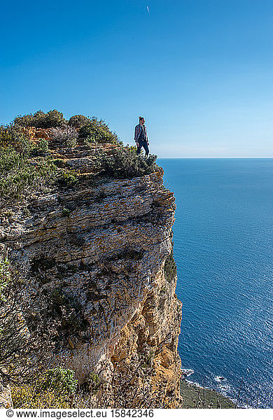 ein Mann auf einer dem Mittelmeer zugewandten Klippe