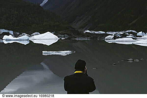 Ein Mann fotografiert das Gletschereis an einem See in Alaska