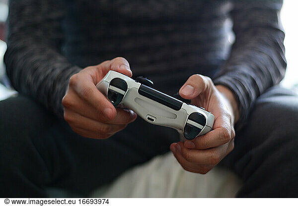 Ein Mann hält einen Spiel-Controller. Ein junger Mann spielt Videospiele