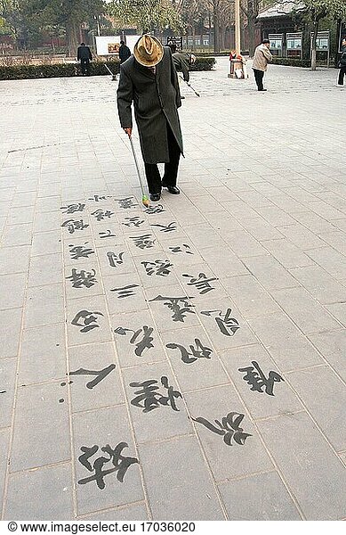 Ein Mann schreibt Gedichte mit Kalligraphie im Sommerpalast. Peking  China. Volksrepublik China.