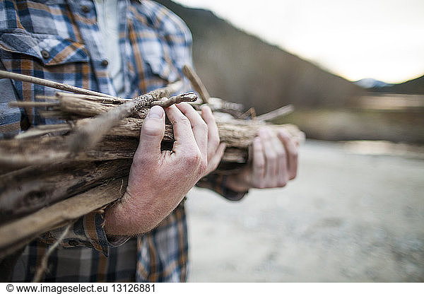 Ein Mann trägt Brennholz im Silver Lake Provincial Park in der Mitte