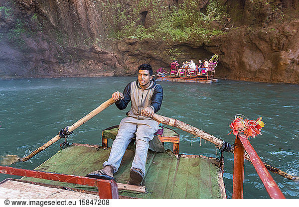 Ein Marokkaner paddelt auf einem Touristenboot bei Ouzoud