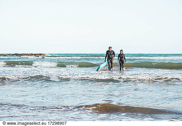 Ein paar Surfer kommen aus dem Wasser am Strand von Benicasim in Spanien