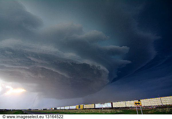Ein rotierender Superzellensturm droht über einem fahrenden Zug  südöstlich von Scottsbluff  Nebraska  USA
