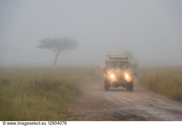Ein Safari-Fahrzeug fährt bei einem Regenschauer  Seronera  Serengeti-Nationalpark  Tansania