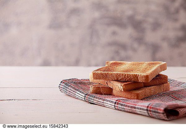 Ein Stapel Toastbrotscheiben auf weißem Holzuntergrund