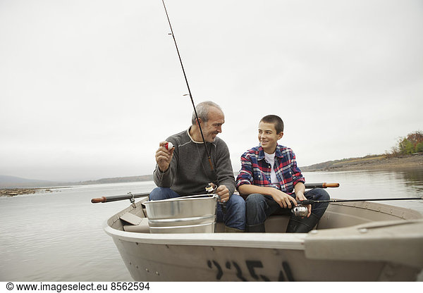Ein Tagesausflug am Ashokan-See. Ein Mann und ein Junge sitzen beim Angeln vom Boot aus.