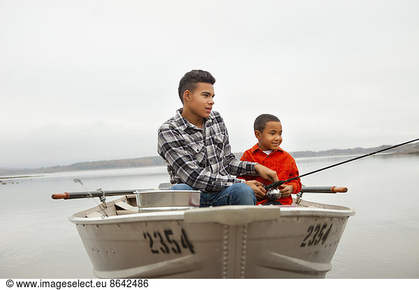 Ein Tagesausflug am Ashokan-See. Zwei Jungen sitzen beim Angeln von einem Boot aus.