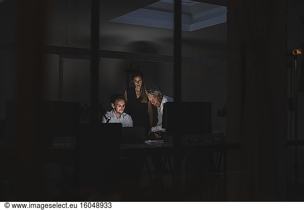Ein Team von Geschäftsleuten arbeitet bis spät in die Nacht im Büro  um Lösungen zu diskutieren