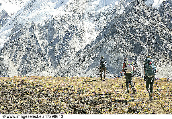 Ein Team von Trekkern wandert durch eine Hochweide im Himalaya