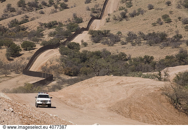Ein US-Grenzschutz-Auto patroulliert am Zaun der in der Sonoran-Wüste westlich von Nogales die USA von Mexiko trennt Nogales Arizona USA