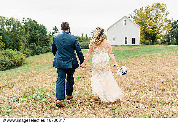 Eine Braut und ein Bräutigam laufen Hand in Hand