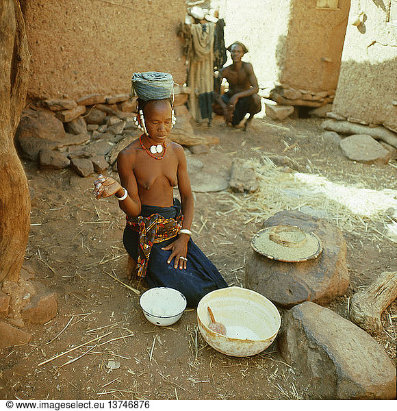 Eine Dogon-Frau dankt  bevor sie mit dem Kochen beginnt  Mali. Dogon. Ende der 1950er - Anfang der 1960er Jahre. Bandiagara-Felsen.