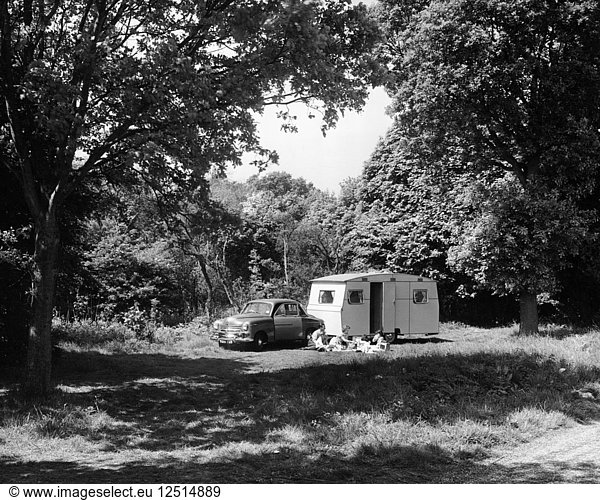 Eine Familie entspannt sich im Urlaub mit ihrem Vauxhall Wyvern von 1951 und einem Wohnwagen  (1951?). Künstler: Unbekannt