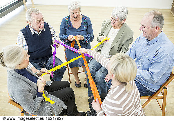 Eine Gruppe von Jugendlichen spielt mit bunten Bändern für den Bau einer Gemeinschaft