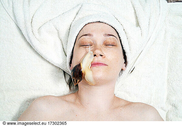 Eine 40-jährige Frau verjüngt ihr Gesicht mit einer Schnecke