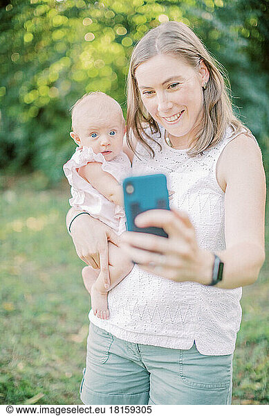 Eine 30-35 Jahre alte kaukasische Mutter macht ein Selfie mit ihrem 4 Monate alten Kind.