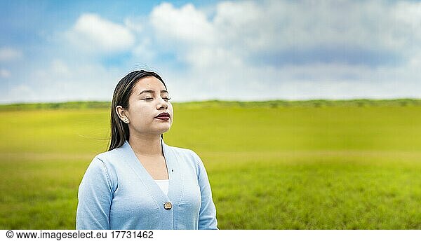 Eine junge Frau atmet tief durch auf dem Feld  Ein junges Mädchen atmet frische Luft auf dem Feld  Junge Frau atmet frische Luft auf dem Feld am Morgen