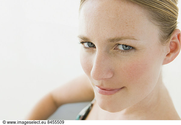 Eine junge Frau mit blauen Augen  die in die Kamera schaut.