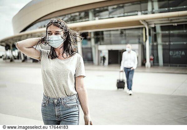 Eine junge Frau verlässt den Flughafen mit ihrem Gepäck  bereit  ein neues Ziel zu entdecken