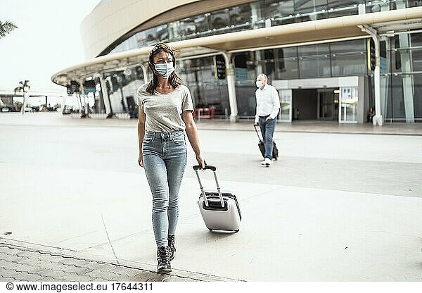 Eine junge Frau verlässt den Flughafen mit ihrem Gepäck  bereit  ein neues Ziel zu entdecken