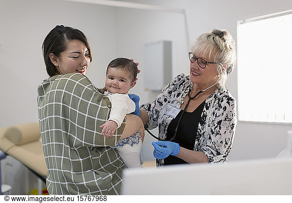 Eine Kinderärztin untersucht ein kleines Mädchen im Untersuchungsraum