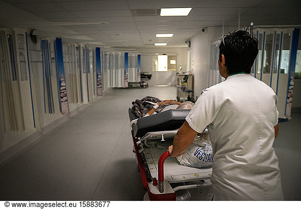 Eine Krankenschwester transportiert eine ältere Patientin.