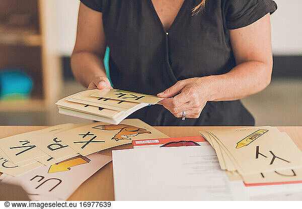 Eine Lehrerin sortiert die Bildkarten des Alphabets in ihrem Klassenzimmer.