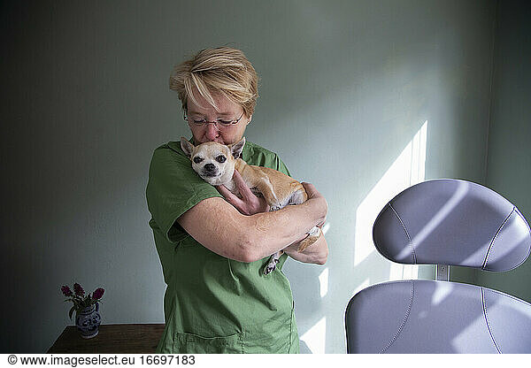 Eine medizinische Mitarbeiterin hält ihren Hund und küsst ihn auf den Kopf