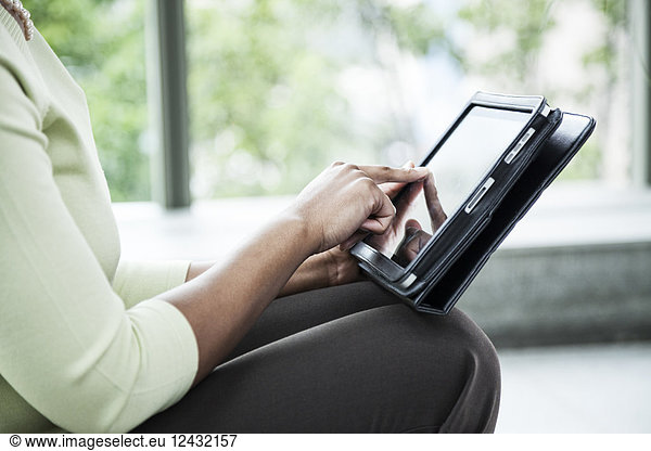 Eine Nahaufnahme der Hände einer schwarzen Geschäftsfrau  die an einem Notebook-Computer arbeitet.