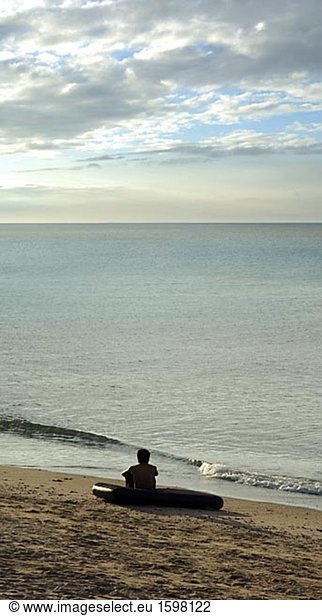 Eine Person  die auf eine Luftmatraze am Strand Puerto Galera Philippinen sitzt.
