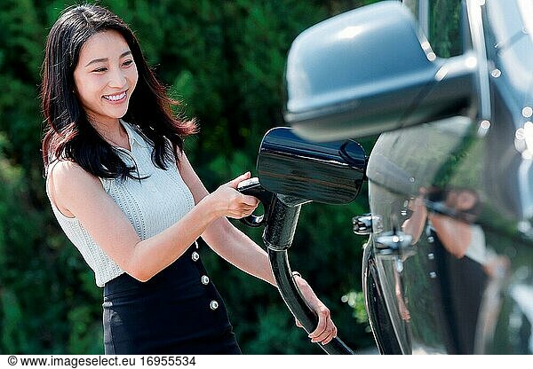 Eine schöne junge Frau auf Autobatterie
