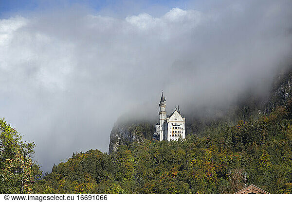 Eine Seitenansicht von Schloss Neuschwanstein durch die Wolken