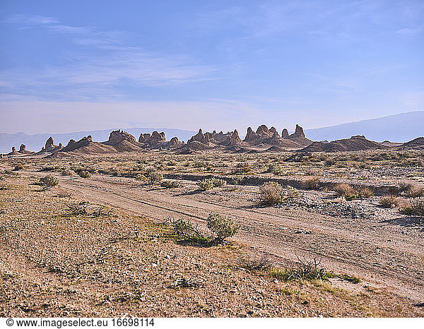 Eine staubige Schotterstraße windet sich durch die Wüste zu den Trona Pinnacles.
