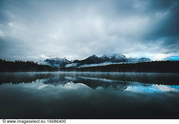 Eine stimmungsvolle Spiegelung der Berge im Banff National Park auf einem ruhigen See