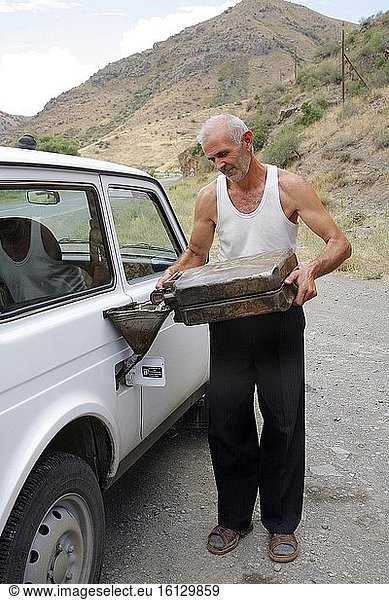 Eine Tankstelle in Armenien. Der Besitzer betankt das Auto von Hand aus einem Benzinkanister. Foto: Andr? Maslennikov