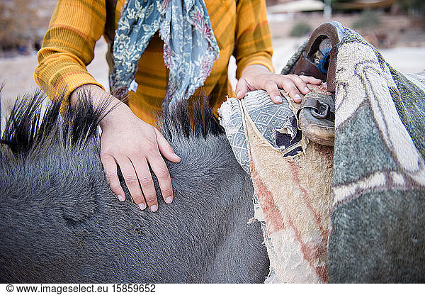 Eine Touristin freundet sich in Petra mit einem einheimischen Esel an.