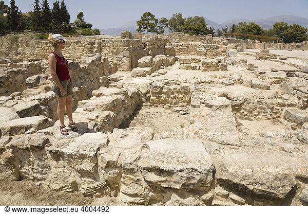 Eine Touristin steht inmitten der Ausgrabungsstätte der minoischen Paläste von Festos  Insel Kreta  Griechenland
