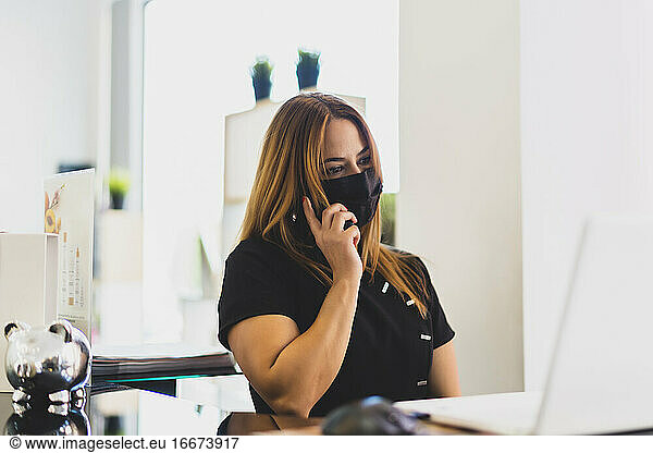 eine unternehmungslustige Frau  die in ihrem Geschäft ans Telefon geht