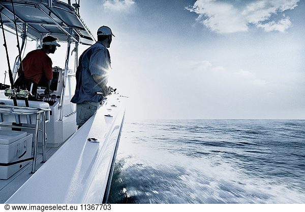 Einfarbige Aufnahme von zwei Männern beim Fahren und Angeln vom Schnellboot aus  Miami  USA