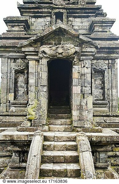 Eingang zu einem Tempel im Candi Arjuna Hindu Temple Complex  Dieng Plateau  Zentraljava  Indonesien. Der Candi Arjuna Hindu Temple Complex ist die Überreste einer Sammlung von Hindu-Tempeln im Zentrum des Dieng-Plateaus. Das Dieng-Plateau ist ein abgelegener Ort in Zentraljava und liegt 2000 m über dem Meeresspiegel. Die aktive Vulkan-Caldera ist berühmt für ihre atemberaubende Berglandschaft  den Hindu-Tempelkomplex auf dem Dieng-Plateau und die auf unbeschreiblich steilen Hängen gelegenen Gemüsefelder.