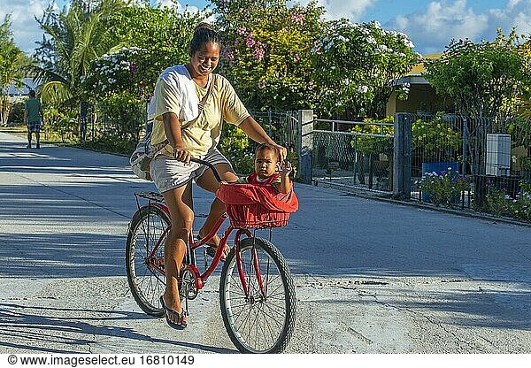 Einheimisches Mädchen mit einem Fahrrad und einem kleinen Kind in Fakarava  Tuamotus-Archipel  Französisch-Polynesien  Tuamotu-Inseln  Südpazifik.