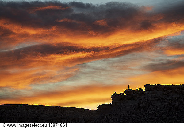 Einsame Figur auf einem Hügel bei dramatischem Sonnenuntergang  Ait Benhaddou  Marokko  Nordafrika  Afrika
