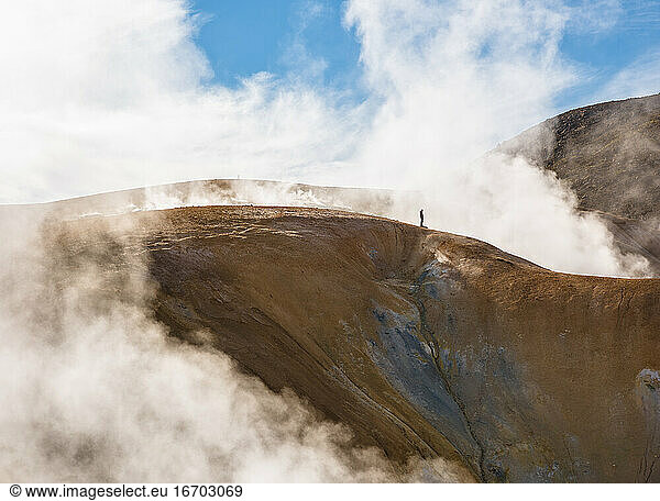 Einsamer Reisender auf Bergkette in Wolken