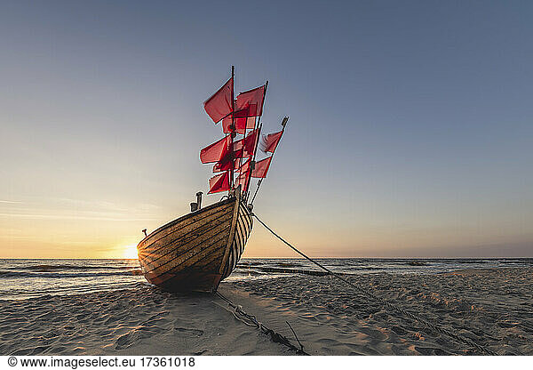 Einsames Fischerboot am Sandstrand bei Sonnenuntergang